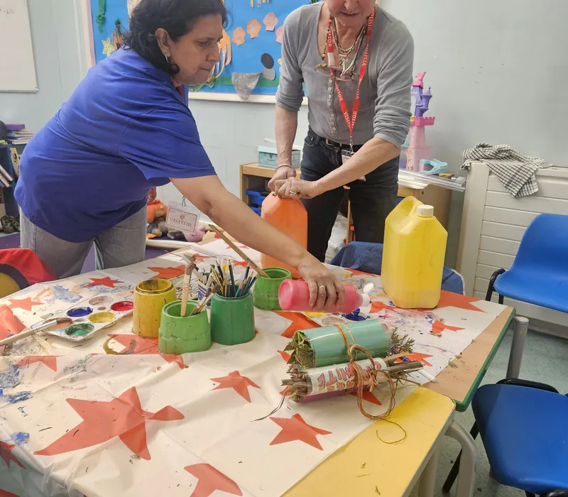 A member decorating card tubes and craft materials at a table in the store