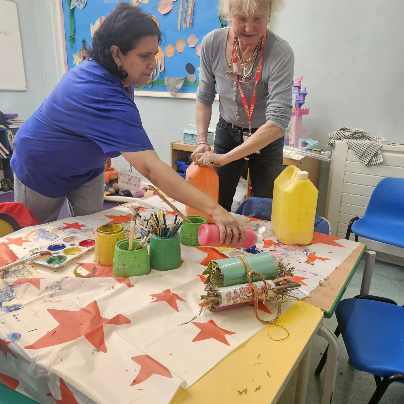 A member decorating card tubes and craft materials at a table in the store