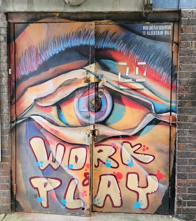 The Scrapstore's mural-painted entrance door on the Hazelhurst Estate, reading Work & Play